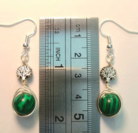 Silver wire wrapped earrings with Tree of Life beads and green malachite round beads measured against a ruler at 2 inches