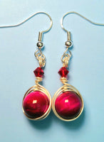 Image of 1 pair of earrings with pink tiger eye 10mm beads wrapped by silver wire and topped by a red 4mm Swarovski crystal