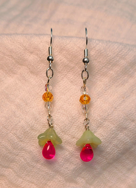 Image of light green and hot pink flowers topped by clear and orange glass beads hung from Silver hooks on white cloth earrings