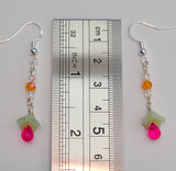 Image of light green and hot pink flower earrings with a ruler measuring 2 inches