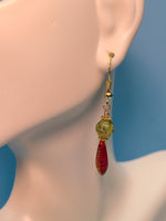 Image of Sparkling Faceted Green,Picasso Finish, Czech glass with Dangling Red Peacock Dagger beads from Gold Toned Sterling Silver Hook on a mannequins ear. 