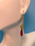 Image of Sparkling Faceted Green,Picasso Finish, Czech glass with Dangling Red Peacock Dagger beads from Gold Toned Sterling Silver Hook on a mannequins ear. 