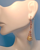 Mannequin wearing one copper spiral earring with round jasper bead and clear Austrian crystal 