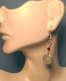 Image of a Green Aventurine earring wrapped by silver wire topped by a daisy bead and red Swarovski crystal hanging from a mannequin