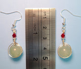 Image of a pair of Green Aventurine earrings wrapped by silver wire topped by a daisy bead and red Swarovski crystals against a ruler measuring 1 3/4 inches