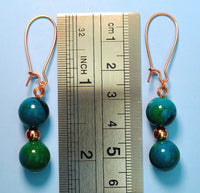 Image of earrings made of Phoenix beads separated by a copper bead pictured with a ruler measuring 2 1/4 inches