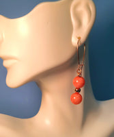 Image of a mannequin wearing an earring of Pale Red Chalcedony beads separated by a copper bead