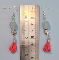 Image of 2 pairs of earrings one with aqua colored recycled glass beads from Ghana, tree of life beads and pink tassels hung on silver wire next to a ruler measuring 2 3/4"