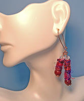 A mannequin wearing an earring made of Silk Sari Yarn, round Sandalwood beads, crystal beads and copper wire