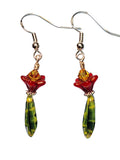 Red 5 point flowers topped by yellow Swar. crystals over green dagger beads dangling from sterling silver hooks. 